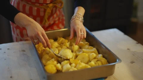 A person is preparing a dish in a large pan Stock Footage 295369627