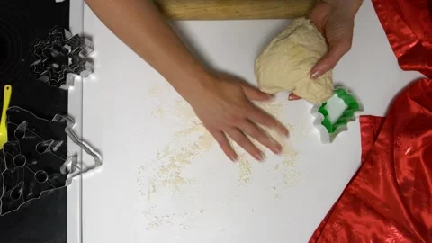 A person is preparing dough on a white surface, sprinkling flour and using Stock Footage 336066627