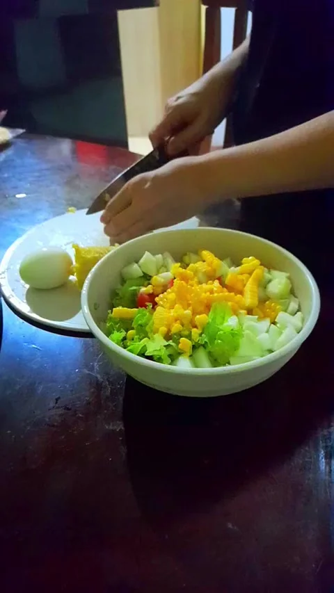 Person preparing fresh salad with eggs and vegetables in the kitchen Stock Footage 294265656