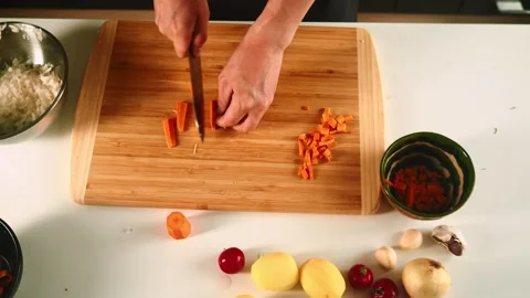 A person is preparing fresh vegetables, chopping carrots, and other ingredients Video stock 316634245