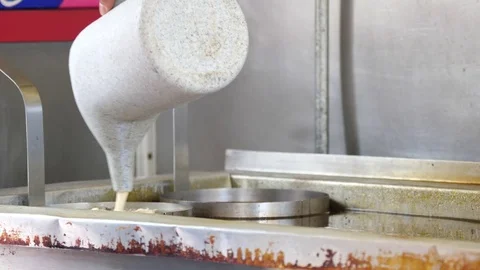 Person preparing funnel cake in deep oil Stock Footage