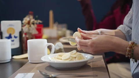 Person preparing a healthy nutritious fruit breakfast at a dining table with Stock Footage 342264739