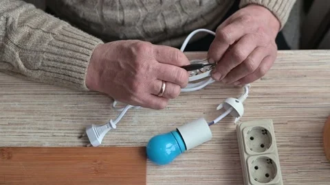 A person is preparing a light fixture by connecting electrical components, 库存影片 337111459
