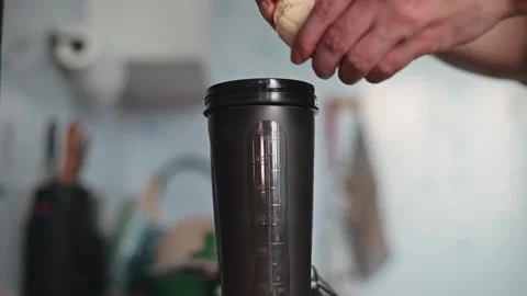A person is preparing a mixture by placing ingredients into a container in a Stock Footage 339096650