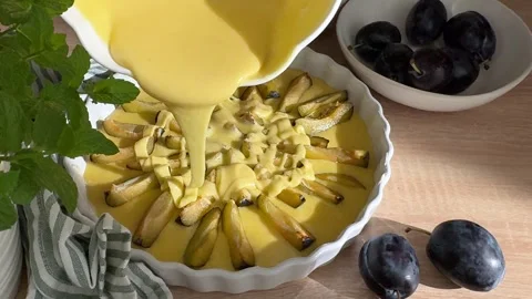 Person preparing plum pie pouring batter 스톡 동영상 344974589