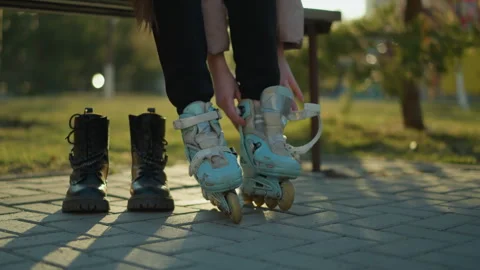 Person Preparing to Put on Rollerblade in Sunlit Park Setting Stock Footage 284805307
