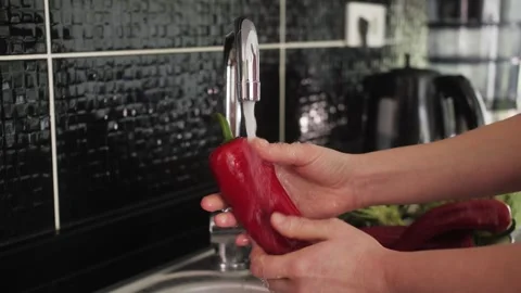 Person preparing salad, washed vegetables in the sink under the tap water. Stock Footage 246124496