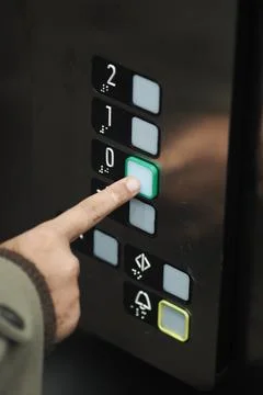 Person presses button in an elevator to go down Foto stock