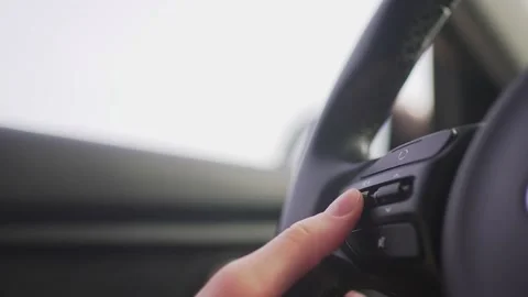 Person presses the button on the steering wheel of the car, close-up. Volume Stock Footage 194562530