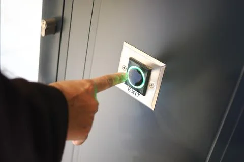 Person presses exit button to leave a building Stock Photos