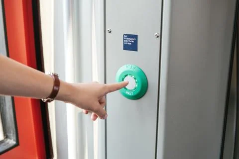 The person presses the stop button in the train. Photos