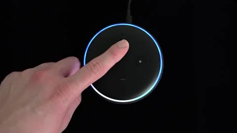Person pressing an Amazon Echo Dot smart speaker with built-in Alexa voice Stock Footage 145334172