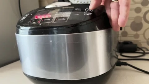 Person pressing button on multicooker control panel close up at home, starting Stock Footage 337104492