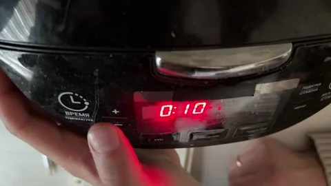 Person pressing button on multicooker control panel close up at home, starting Stock Footage 337104808