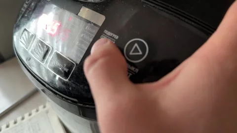 Person pressing button on multicooker control panel close up at home, starting Stock Footage 337104809