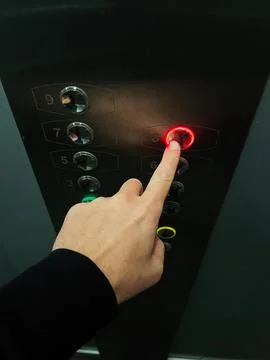 Person pressing elevator button illuminated with red light for eighth floor Stock Photos