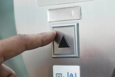 Person pressing elevator button for upward movement Foto stock