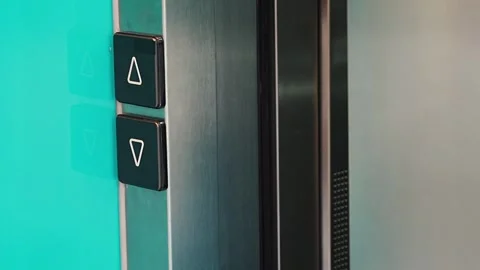 Person pressing elevator call button in modern residential building and entering Stock Footage 346397842