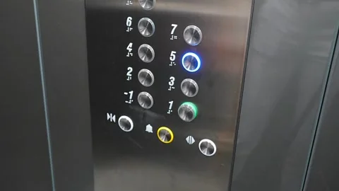 Person pressing the fifth floor button inside a modern elevator. Vertical Stock Footage 346397824