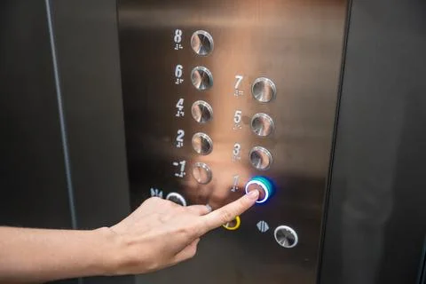 Person pressing the first floor button inside a modern residential elevator Stock Photos