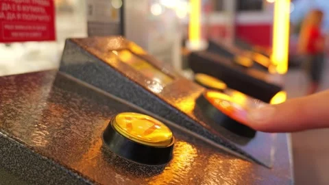 Person pressing illuminated yellow button on arcade game console Stock Footage 340280966