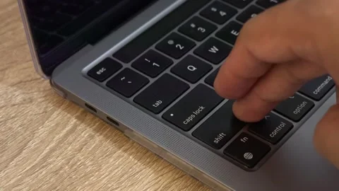 A person pressing a notebook keyboard to turn it on. Close-up. Stock Footage 293127699