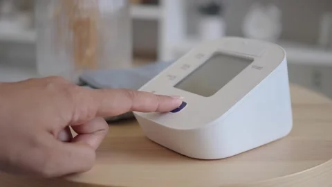 Person Pressing Start Button on Digital Blood Pressure Monitor Stock Footage 340543990