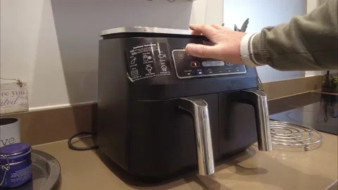 A person programming the air fryer to save money on cooking costs 4k Stock Footage 223524114
