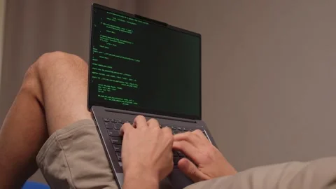 Person programming on laptop with relaxed posture and soft lighting. Individuals Stock Footage 346244594