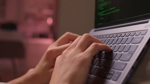Person programming on laptop with relaxed posture and soft lighting. Individuals Stock Footage 346244601