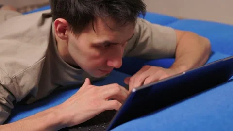 Person programming on laptop with relaxed posture and soft lighting. Individuals Stock Footage 346244857