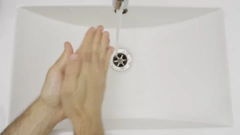Person properly washes hands with soap and water in bathroom sink top shot view Stock Footage 130866411