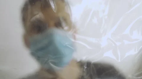 Person with protective gear inside medical technical tent puts hand over plastic Stock Footage 130861778