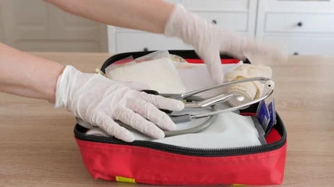 Person in protective gloves is closing first aid kit Stock Footage 139257426