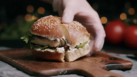 Person Pulling Apart Halves Of A Sliced Halloumi Cheese In A Bun Video stock 134407331