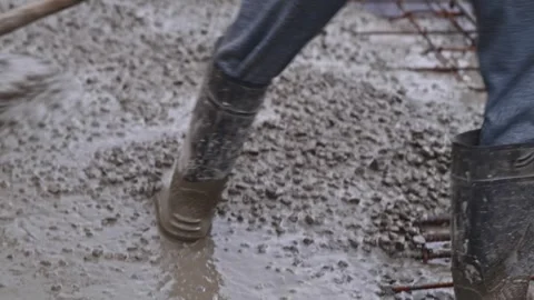 Person pulling concrete mixer through spade tool on slab work at construction Stock Footage 318661224