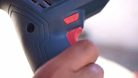 Person pulling drill trigger close up shot, activating power tool, construction Stock Footage 345288830