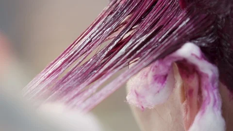Person pulling hair dye through females hair. Stock Footage