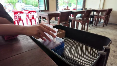 Person Pulling Paper Tissue from Dispenser in Bangkok Restaurant Stock Footage 343505568