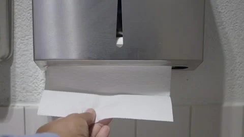 Person pulling a paper towel from a silver dispenser for sanitary hand dryi.. Stock Footage 332879657