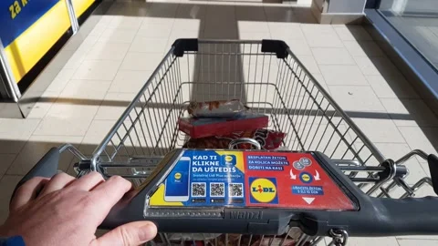 A person pushes a half-empty shopping cart in a Lidl supermarket 库存影片 234888140