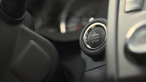 Person pushes large black engine start button on dashboard Stock Footage 116721191