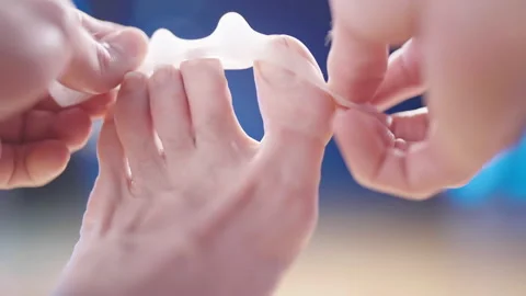 Person put on silicone toe corrector spreader on feet close-up 4K Stock Footage 170126857