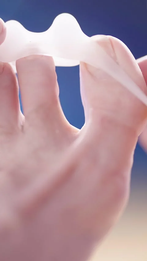 Person put on silicone toe corrector spreader on feet close-up Video stock 324961024