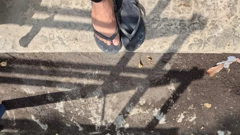 Person puts on black flip-flops outside Stock Footage 341770638
