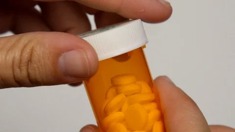 Person puts cap back onto pill bottle. Stock Footage 108033160