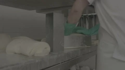 Person puts cheese into molds inside a food factory Stock Footage 222015965
