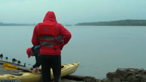 A person puts on a life jacket while another person collects things for SUP Stock Footage 109935808