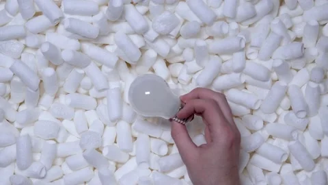 The person puts matte light bulb in a box with a soft filling. Stock Footage 197571832