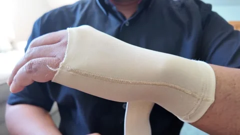 A person puts on a simple fabric wrist brace Stock Footage 328475889